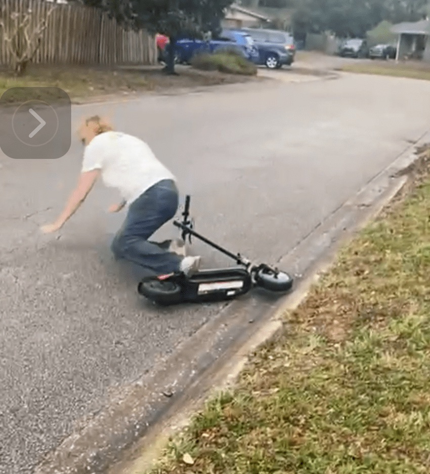 white woman falling off an electric scooter.